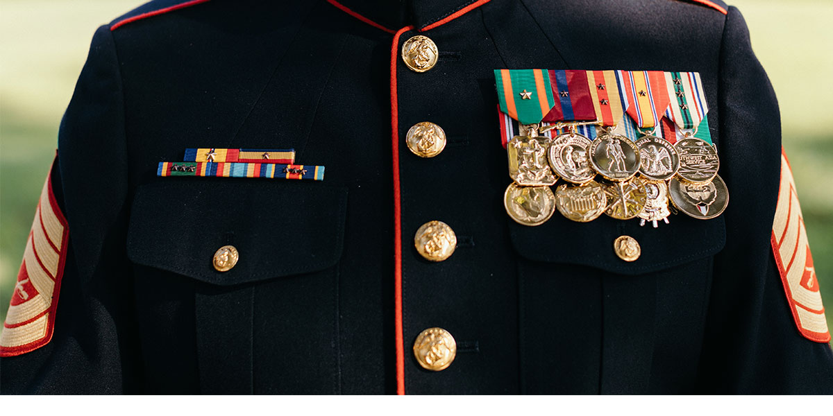 Shining metals fill John Gallegos chest on his Marine Corps Uniform.