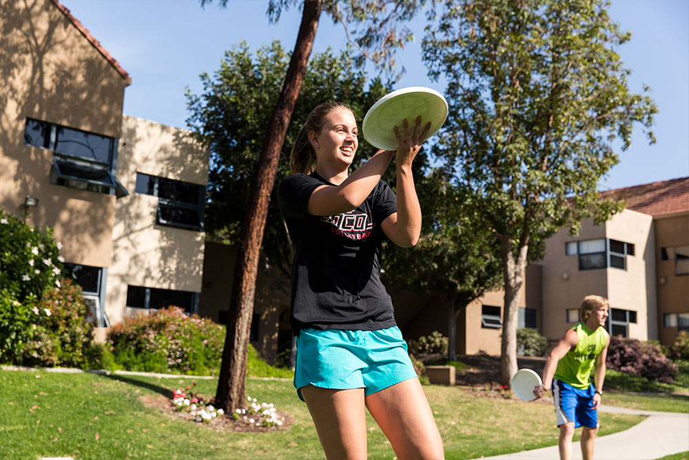 Practicing a two-hand catch as students warm-up for ultimate frisbee