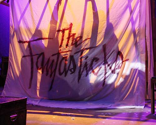 The Fantasticks opening scene of a sheet with silhouette shadows through a sheet