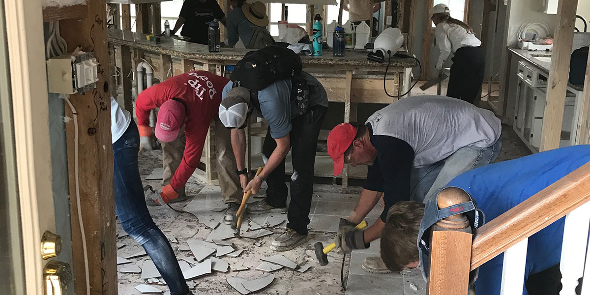 A team of people working together to fix a damaged home